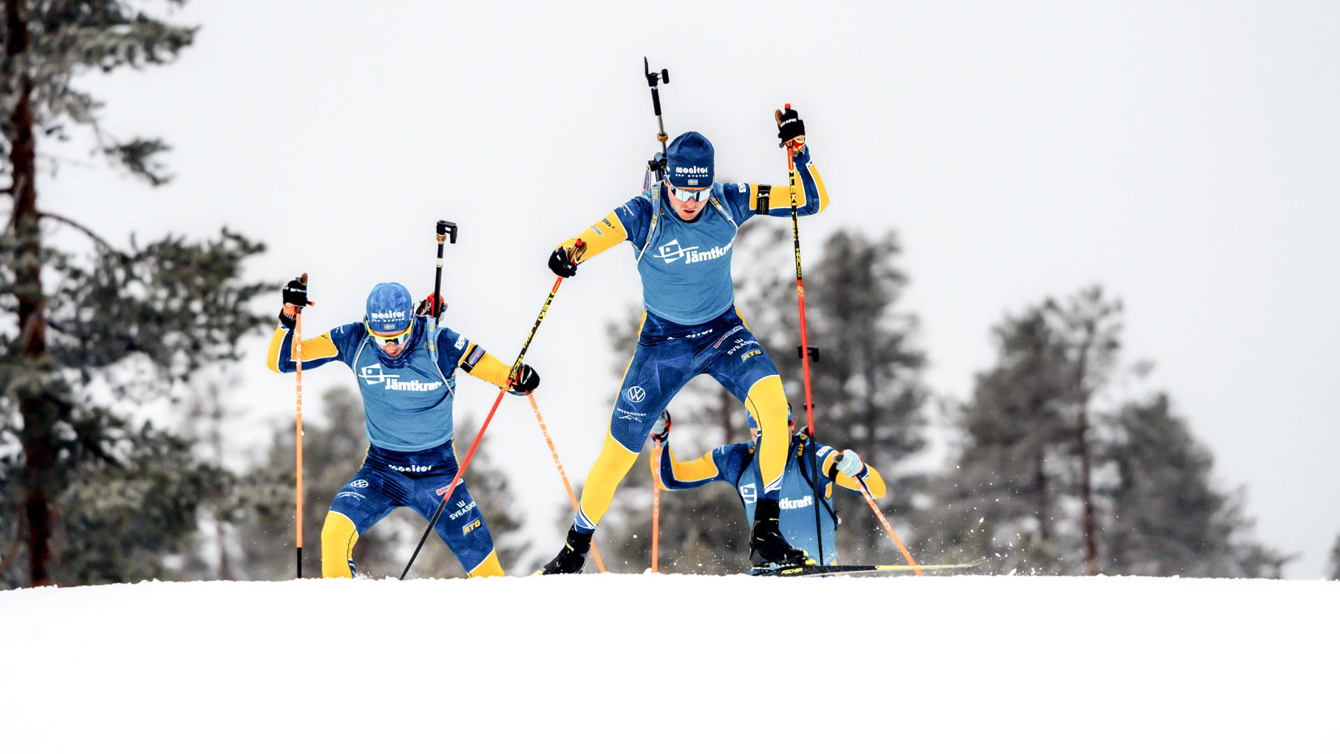 Skidskyttetävling där tre skidskyttar från Sverige åker upp på ett krön.