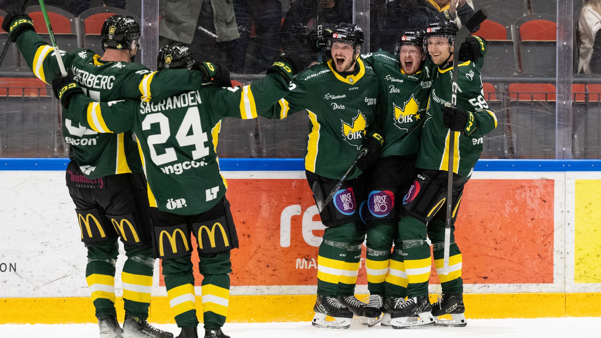En grupp hockeyspelare som står på en hockeyplan.