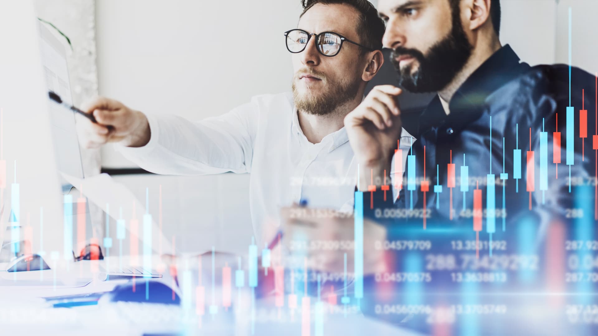 Två män bevakar datadiagram på en bildskärm