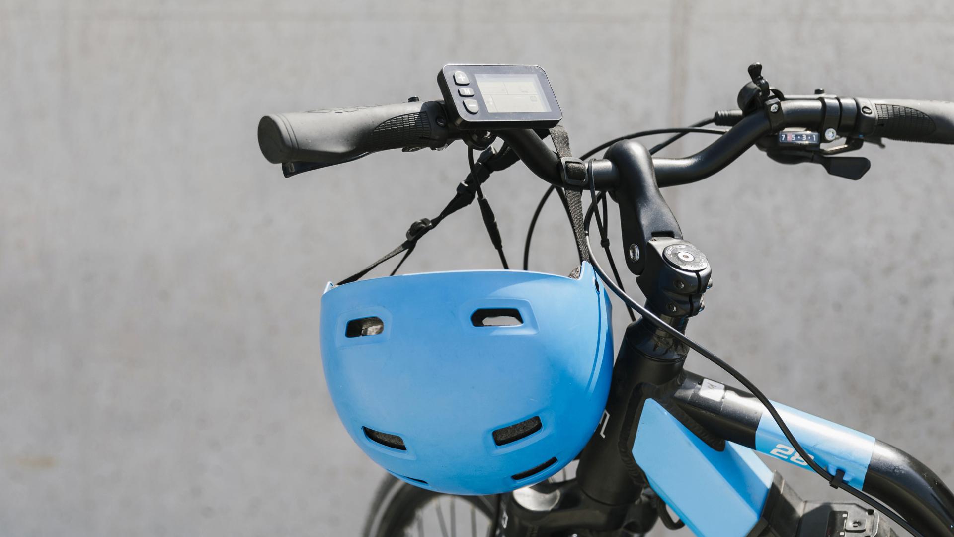 En parkerad elcykel med en hjälm hängande på styret