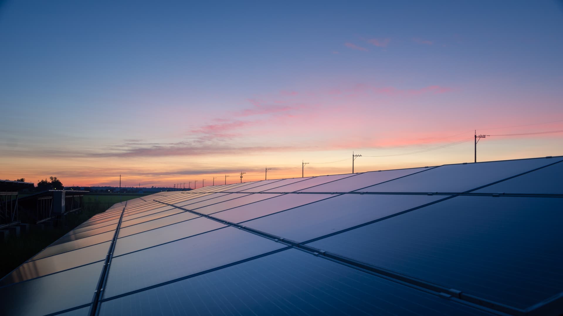 Stora solceller med solnedgång i bakgrunden