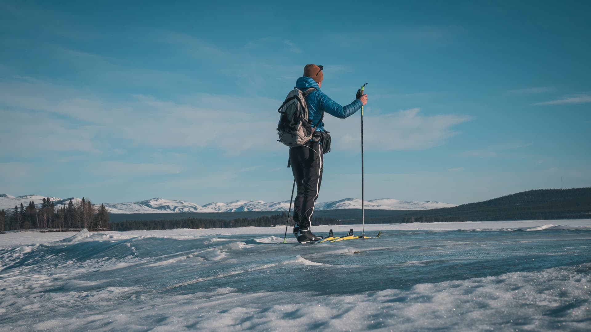 En skidåkare på våris med en fjällkedja i bakgrunden