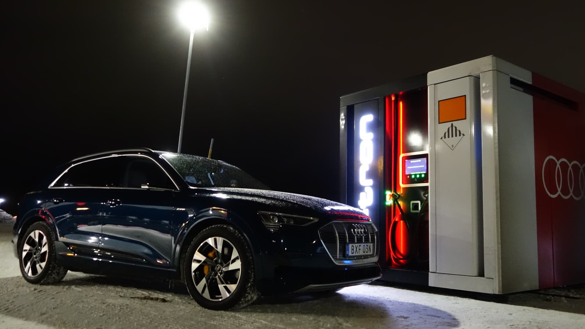 En svart elbil står vid en laddstation.