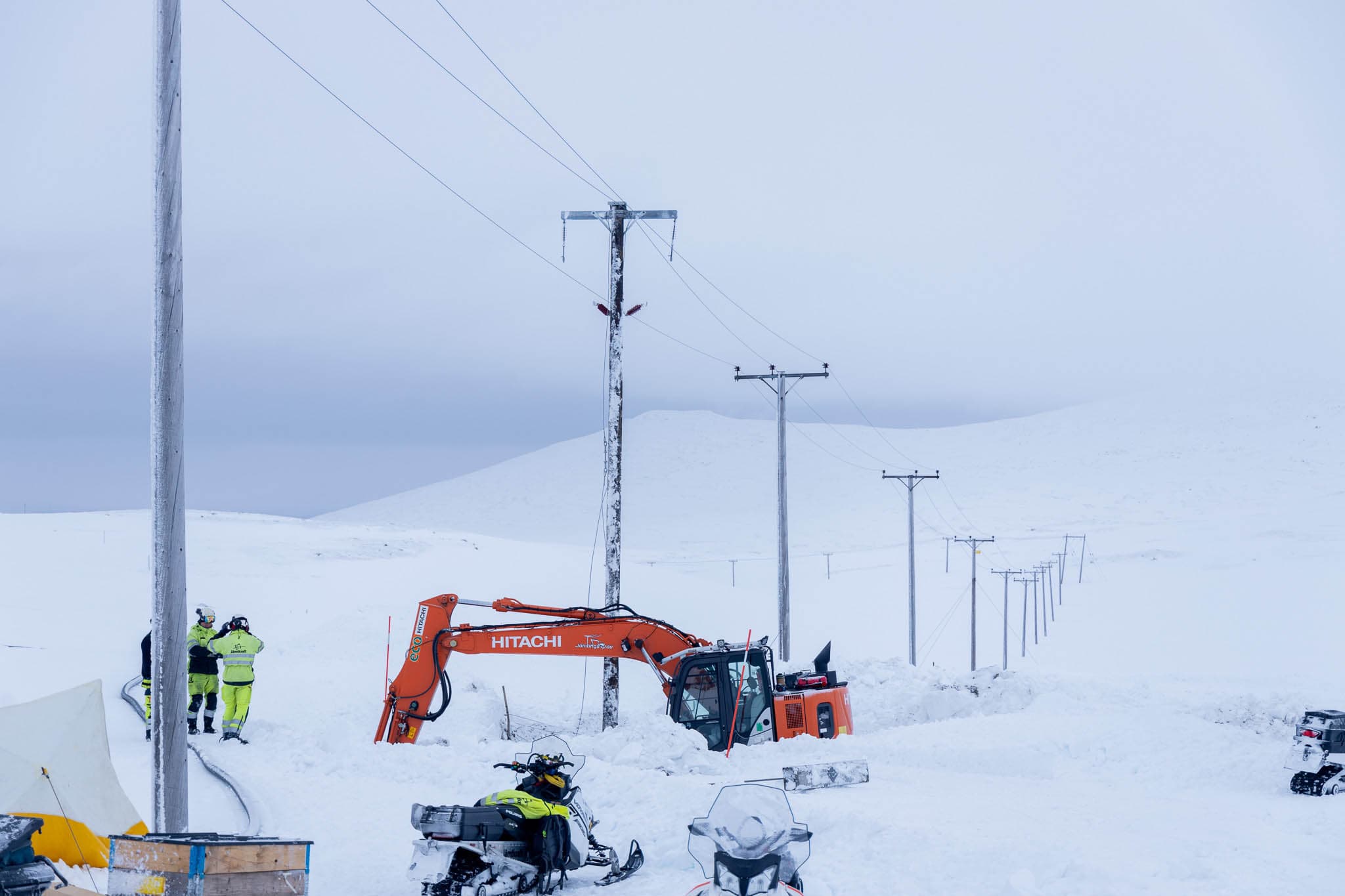 Arbete med elnätet i snötäckt fjällandskap.
