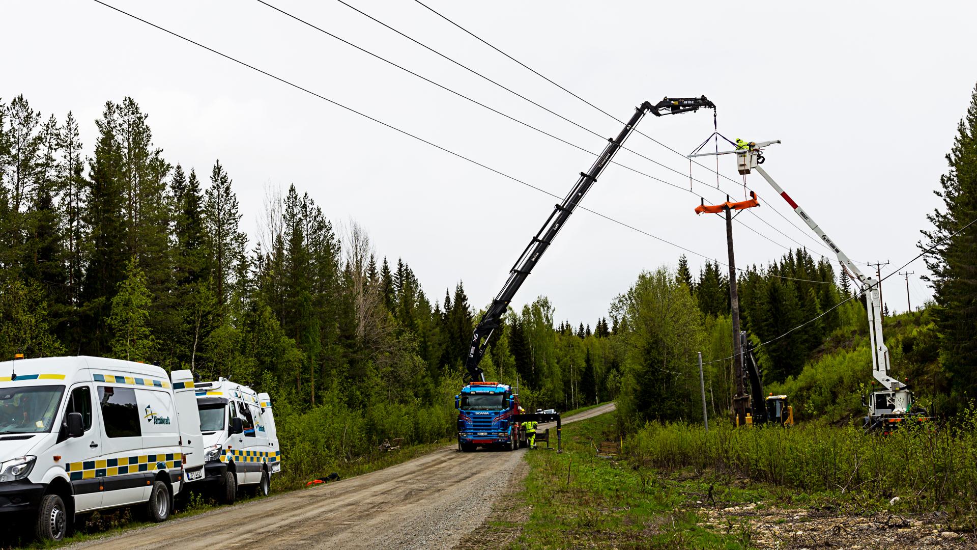 Två kranbilar utför underhållsarbete på elnätet