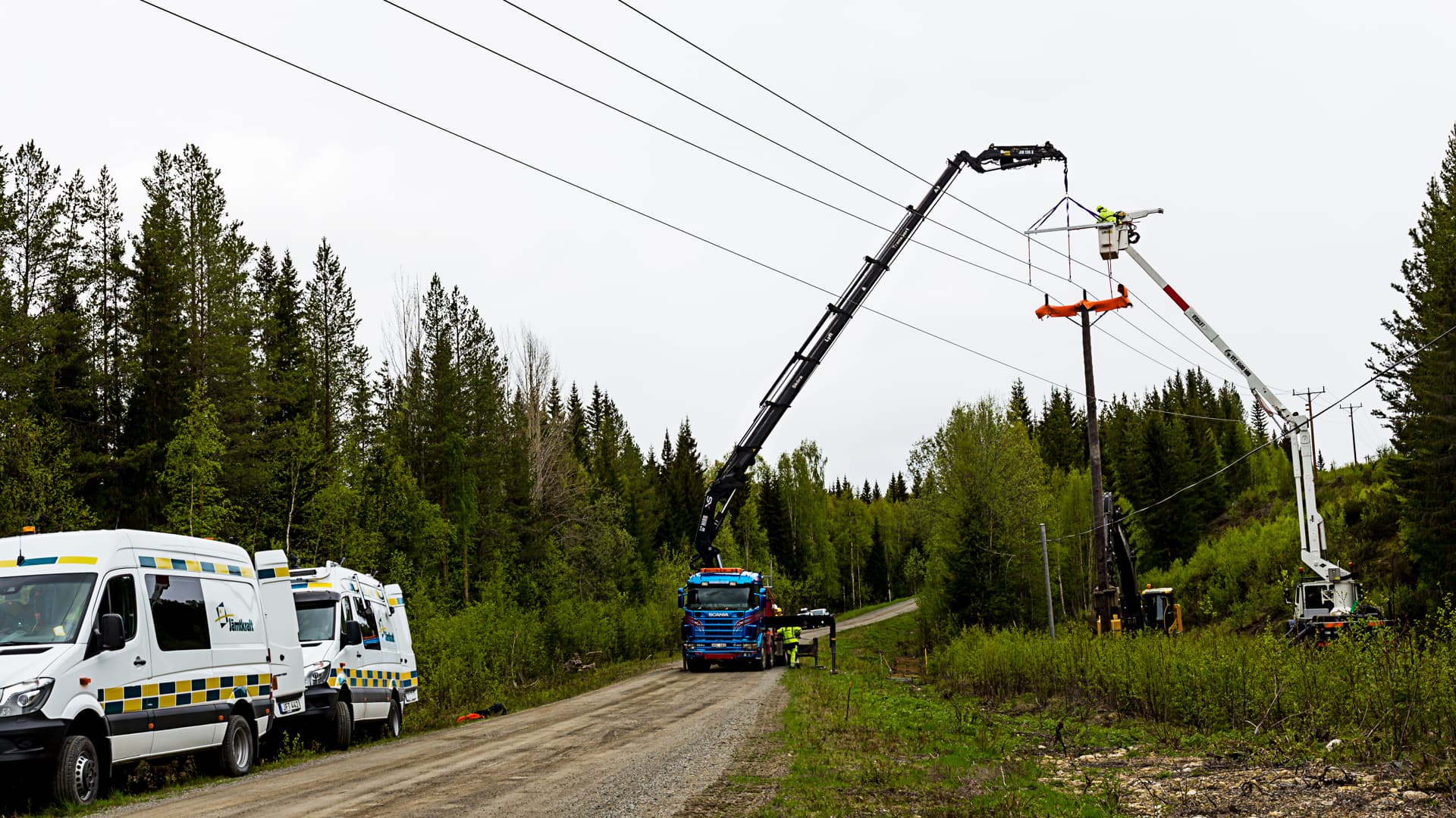 Två kranbilar utför underhållsarbete på elnätet