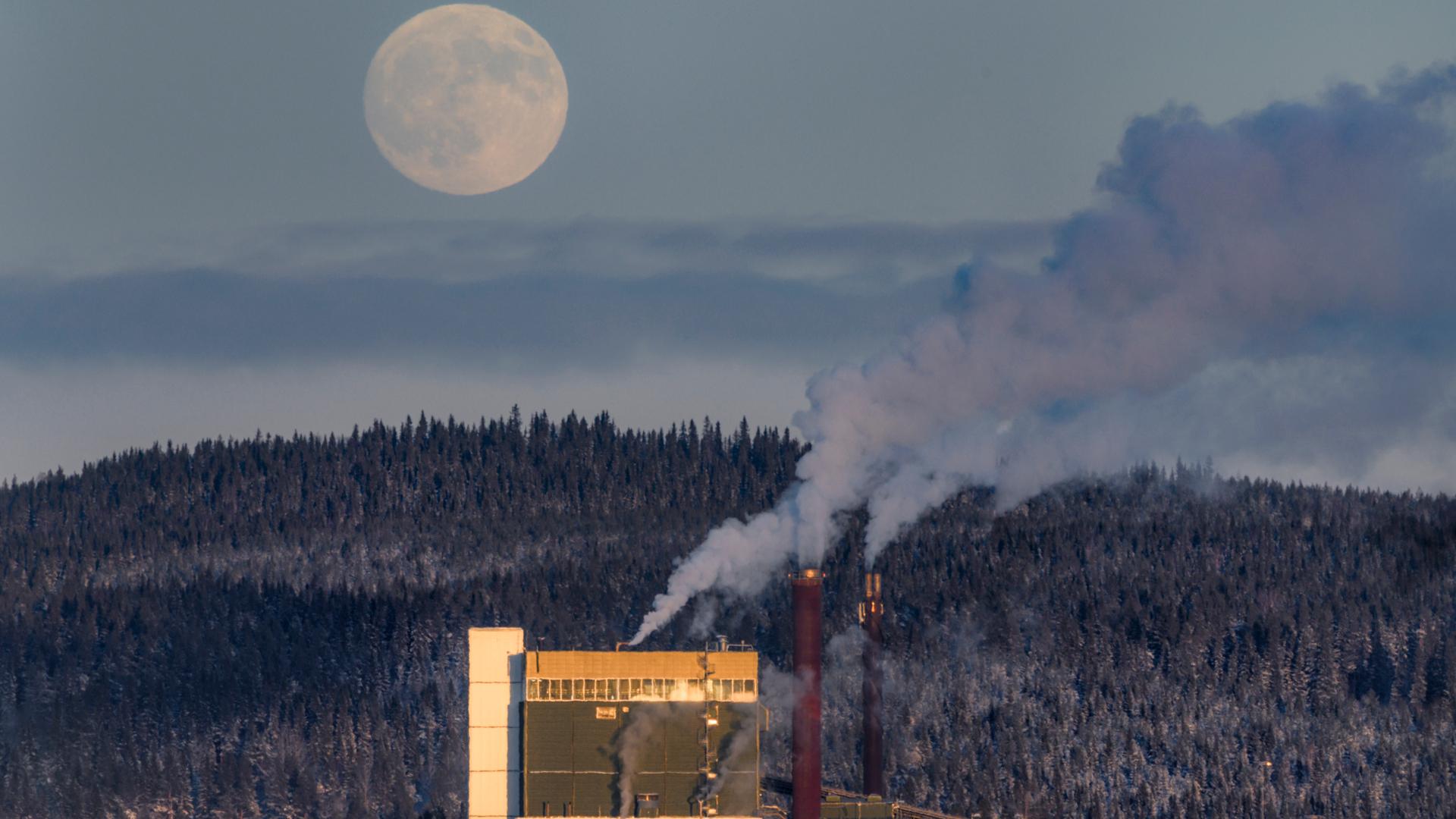 Fjärrvärmeverk under vintern med månen i bakgrunden