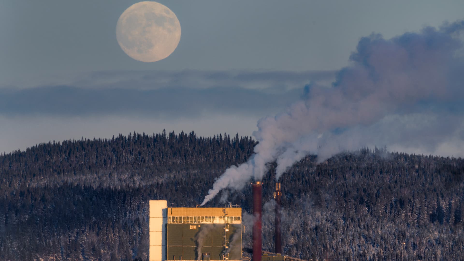 Fjärrvärmeverk under vintern med månen i bakgrunden