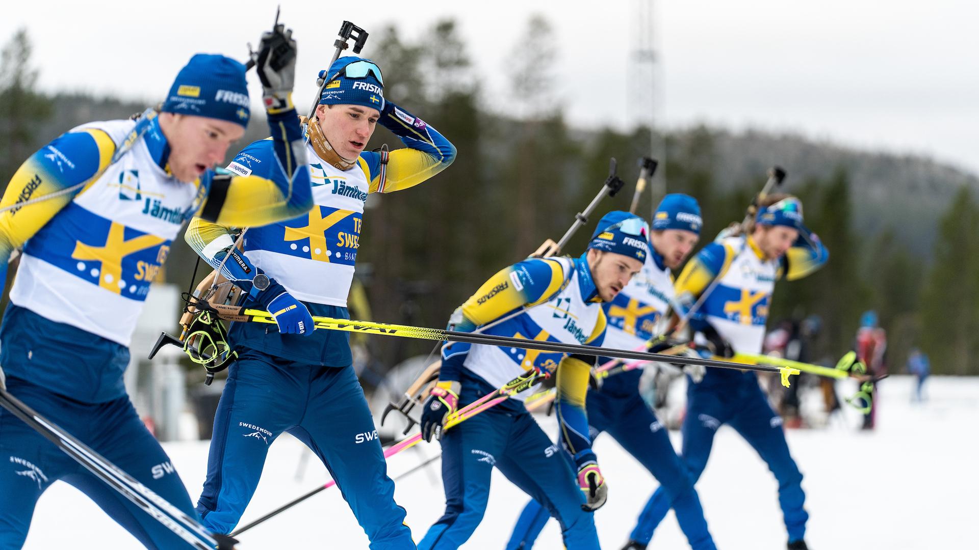 Fem skidskyttar i Sveriges landslagsdräkt gör sig redo för att lägga sig på skjutvallen.