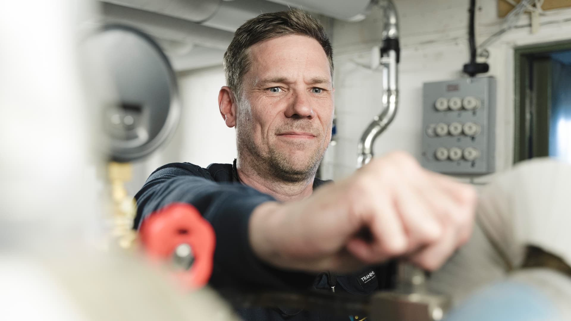 En servicetekniker arbetar med fjärrvärmerör