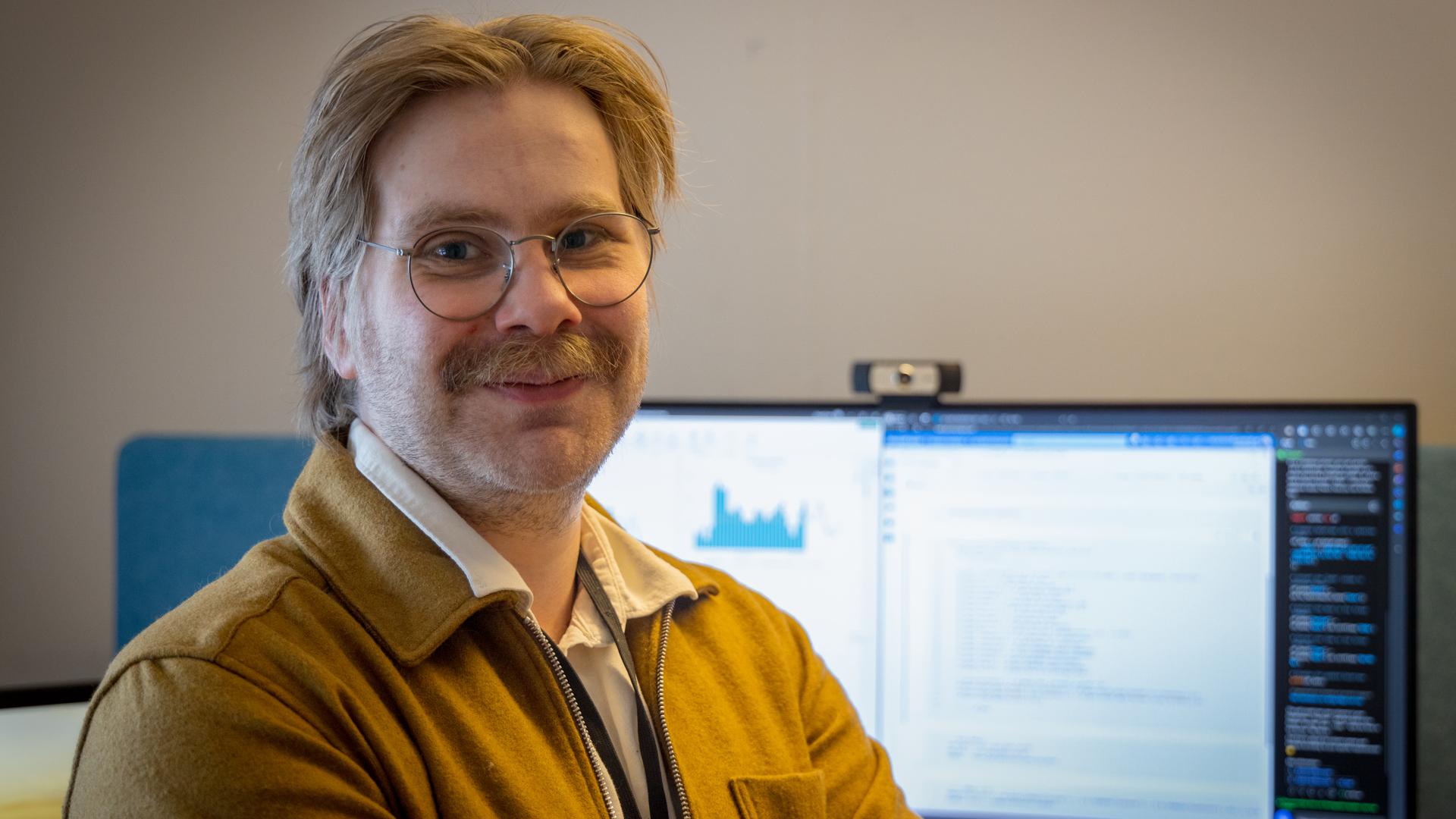 Oscar Ferm står framför en dator.