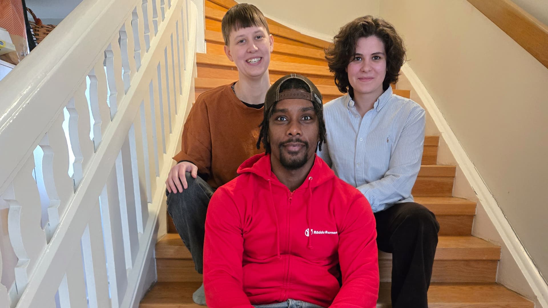 I trappen sitter de tre medarbetarna från Rädda Barnen som är med i reportaget. Överst från vänster sitter Rebecca och Alissar, nedanför sitter Abdo.