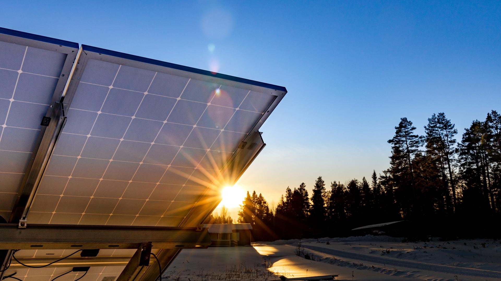 Solceller i solnedgång på vintern