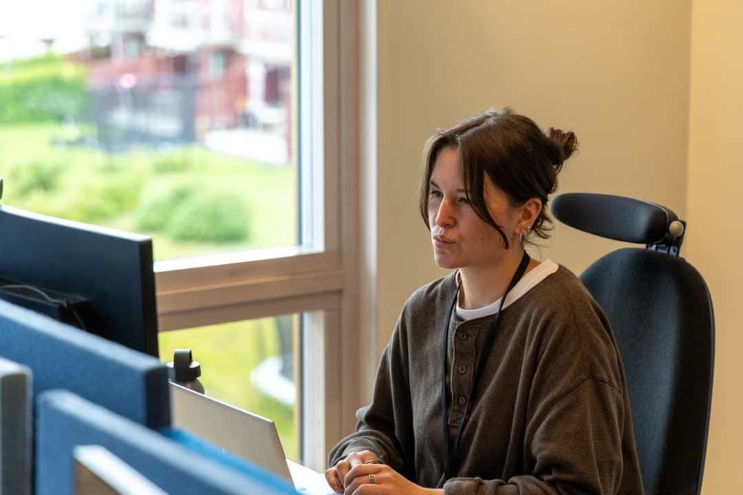 Lovisa Löfvenberg sitter vid en dator och jobbar.