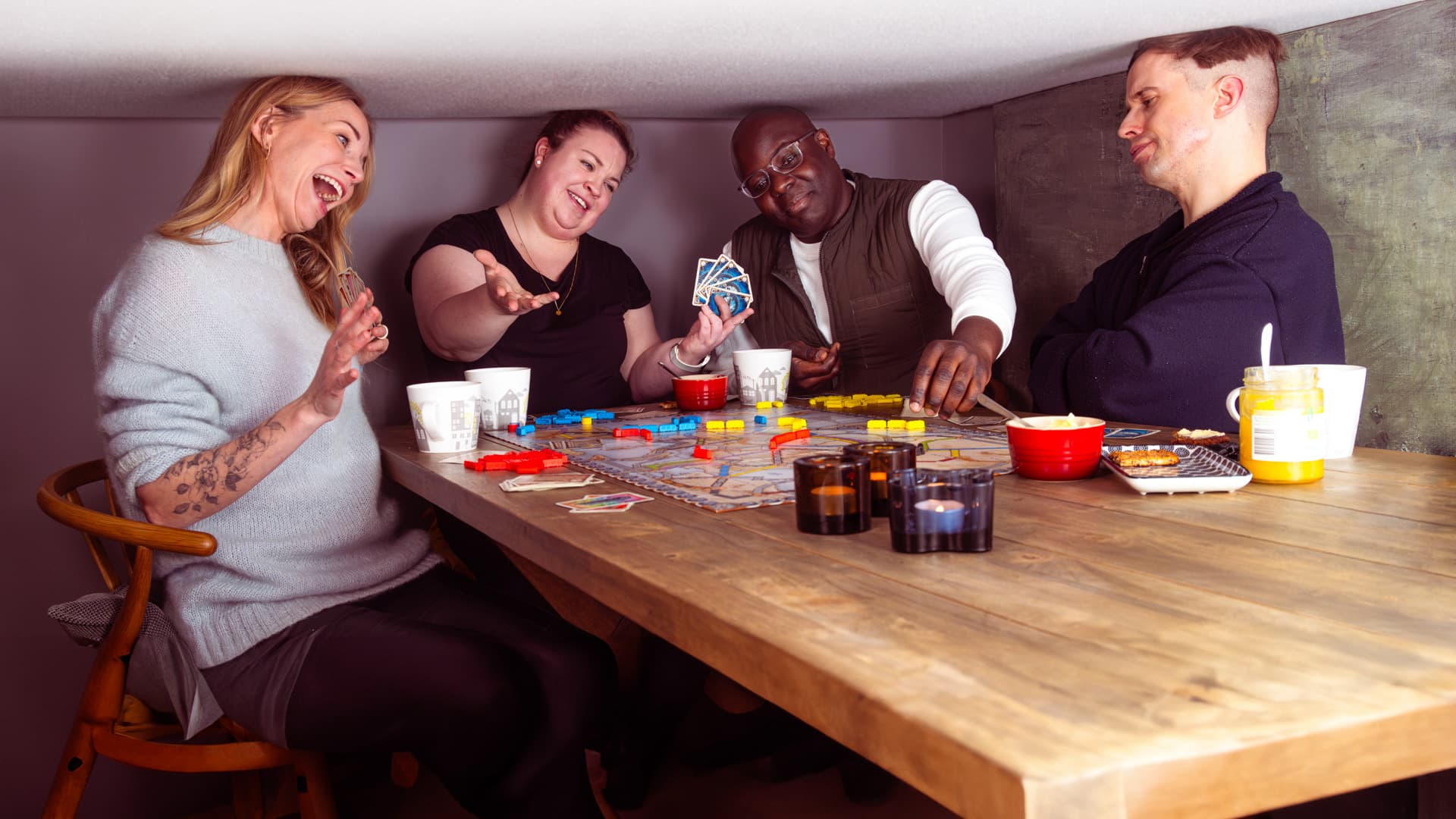 Ett kompisgäng spelar brädspel med väldigt lågt i tak.