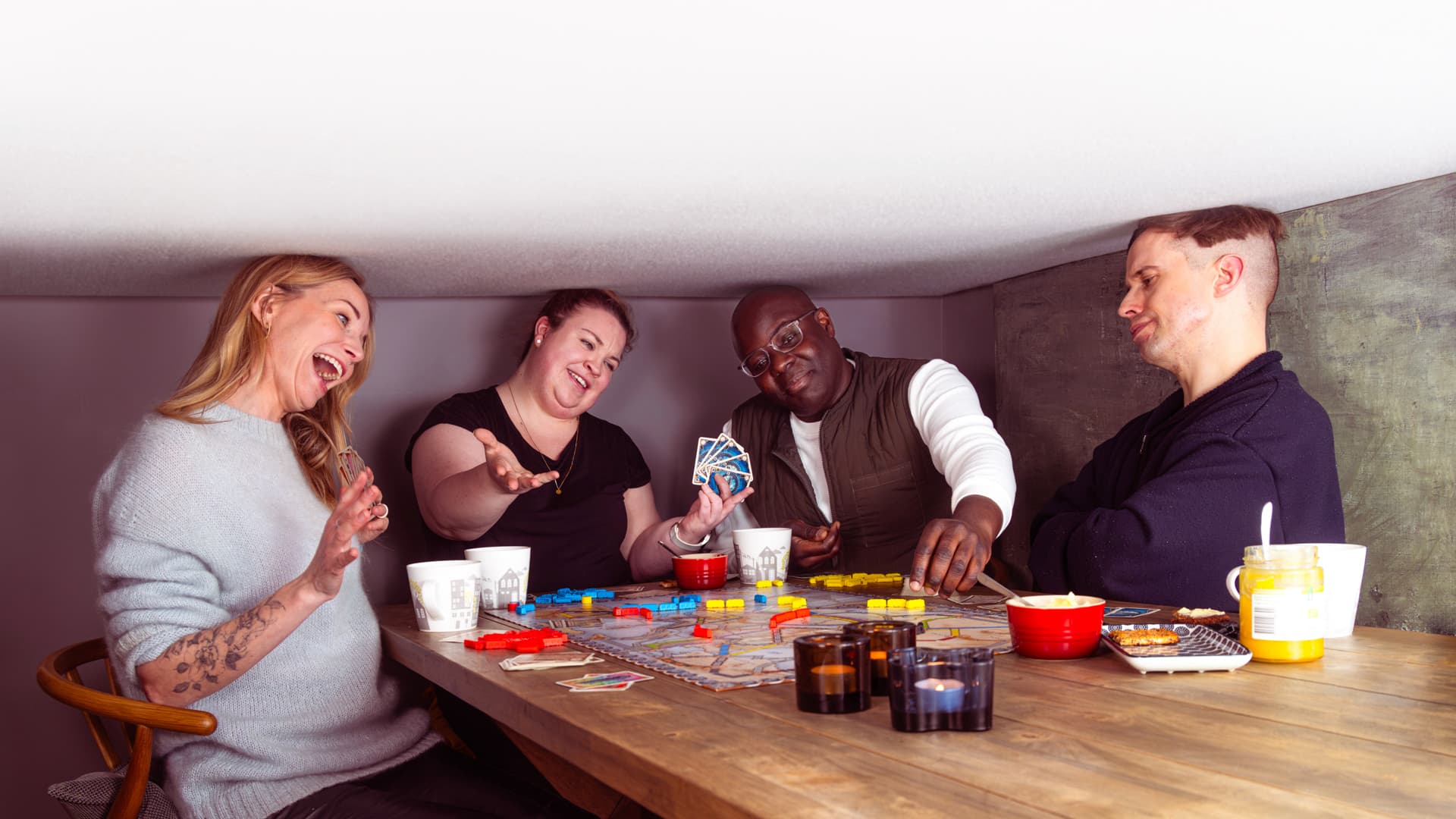 Ett kompisgäng spelar brädspel med väldigt lågt i tak