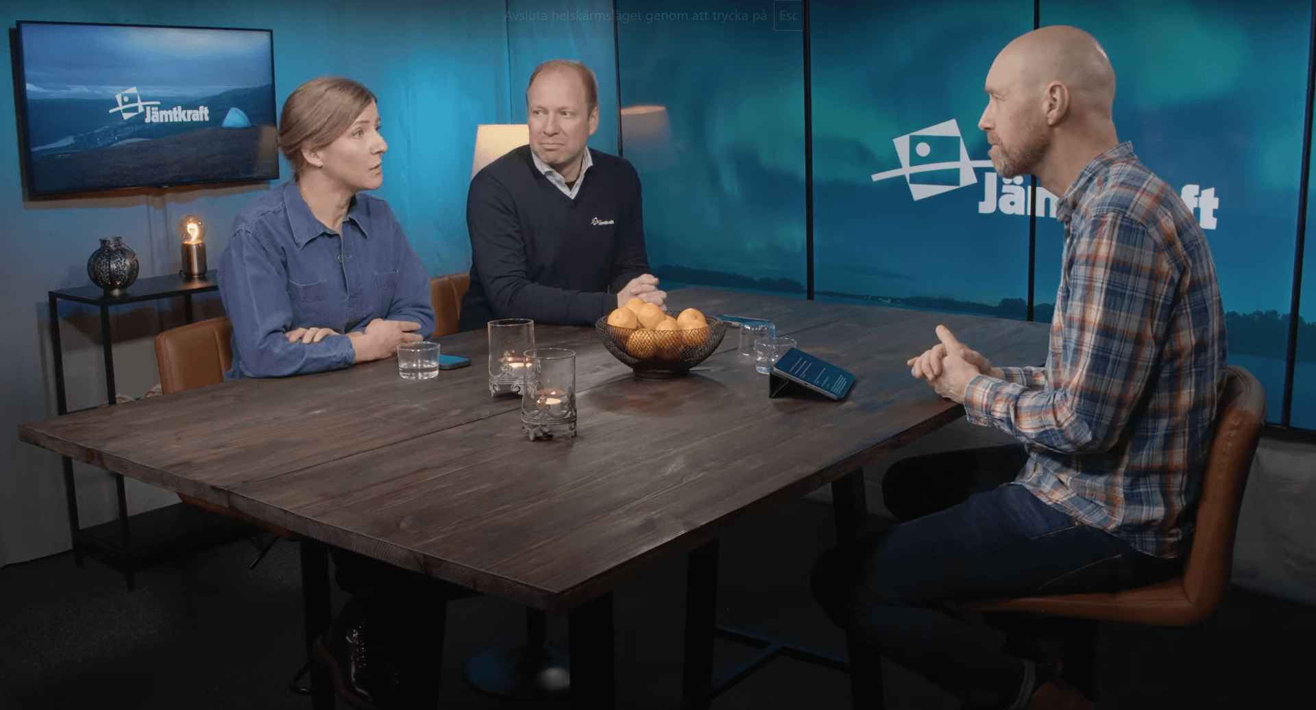 Tre personer sitter vid ett bord och diskuterar.