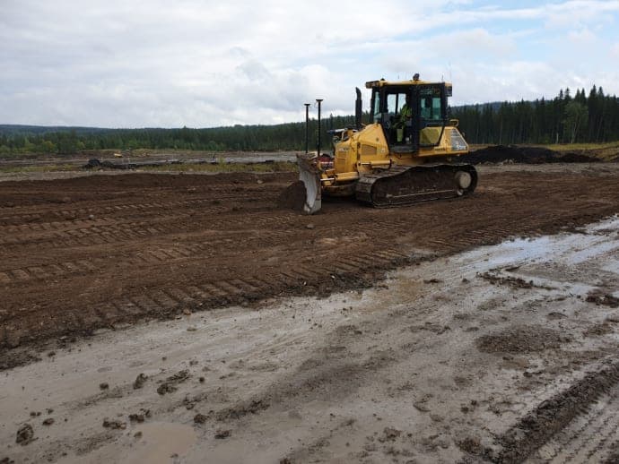 Parkeringsområdet för Östersund Solpark var som en leråker där leran nådde en bra bit upp på stövelskaften regniga dagar. På bilden är parkeringen på väg att prepareras med aska som underlag för en hållbar och stabil yta. Foto: Daniel Ivarsson