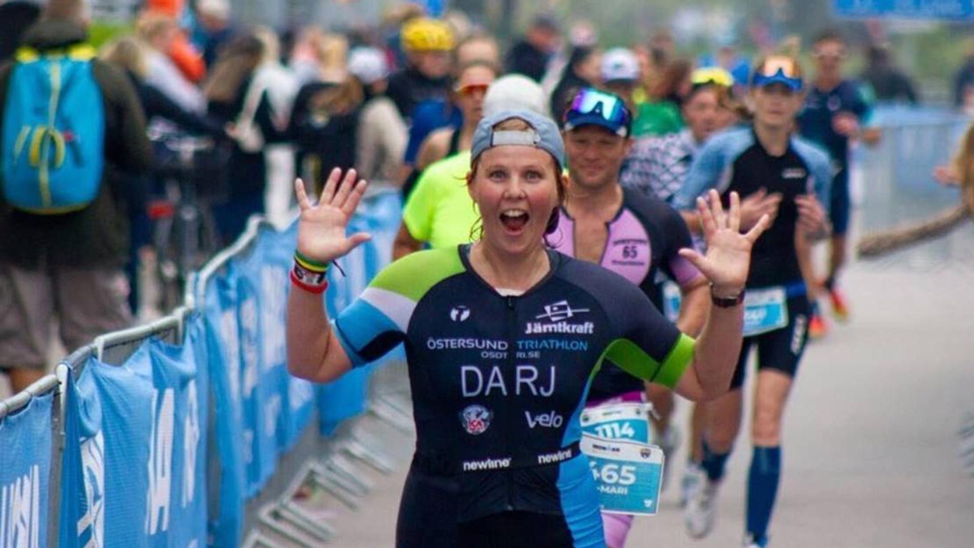 En medlem i Östersund Triathlon springer i mål i en tävling.