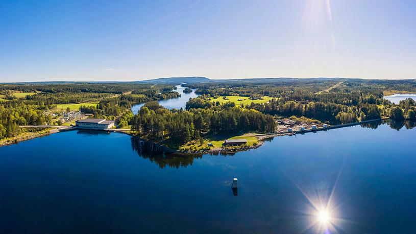 Flygbild över Kattstrupeforsen vattenkraftverk en solig sommardag.