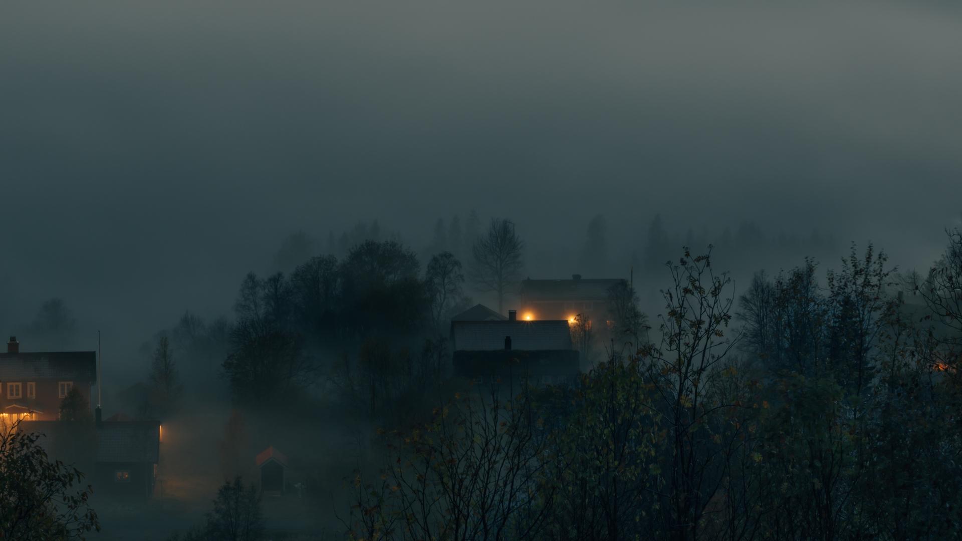 Dimma och oväder över några hus i Åre i gryningen.