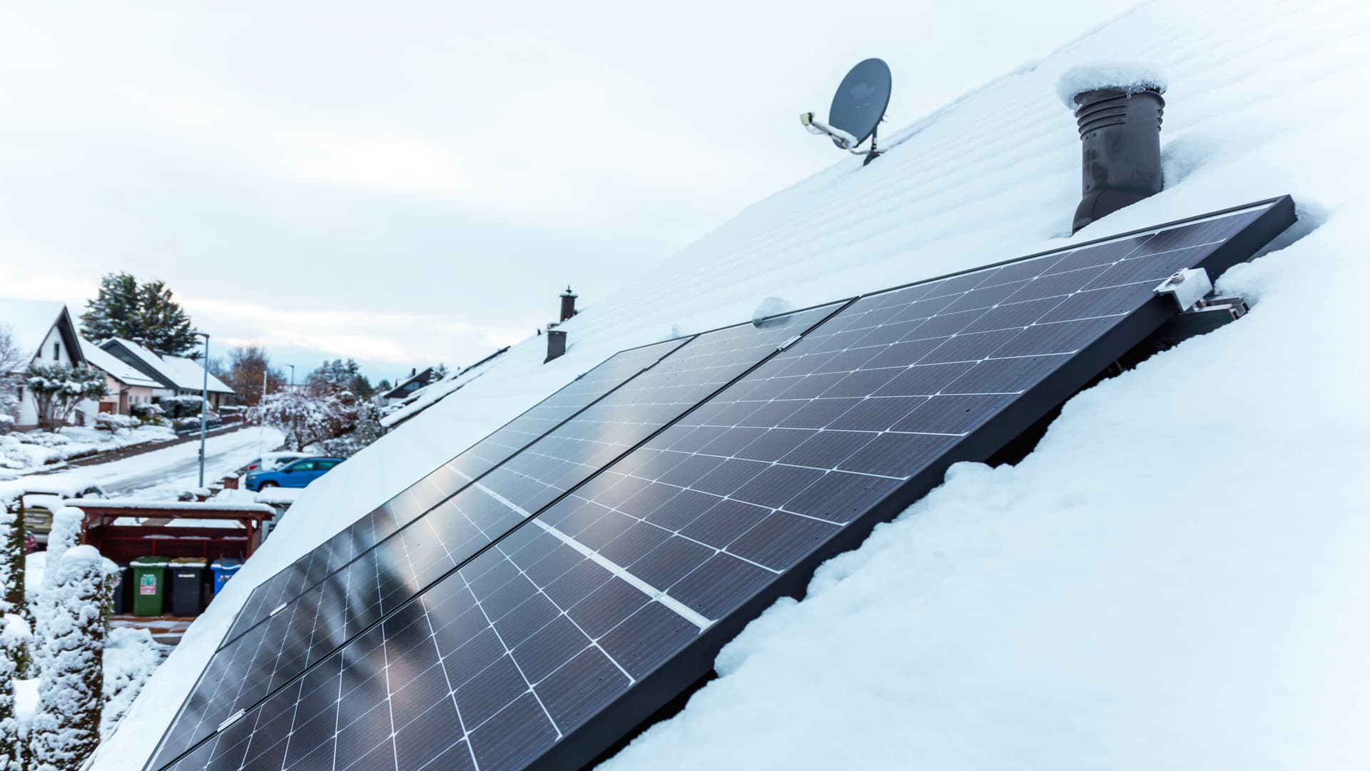 Solceller på ett snötäckt villatak.