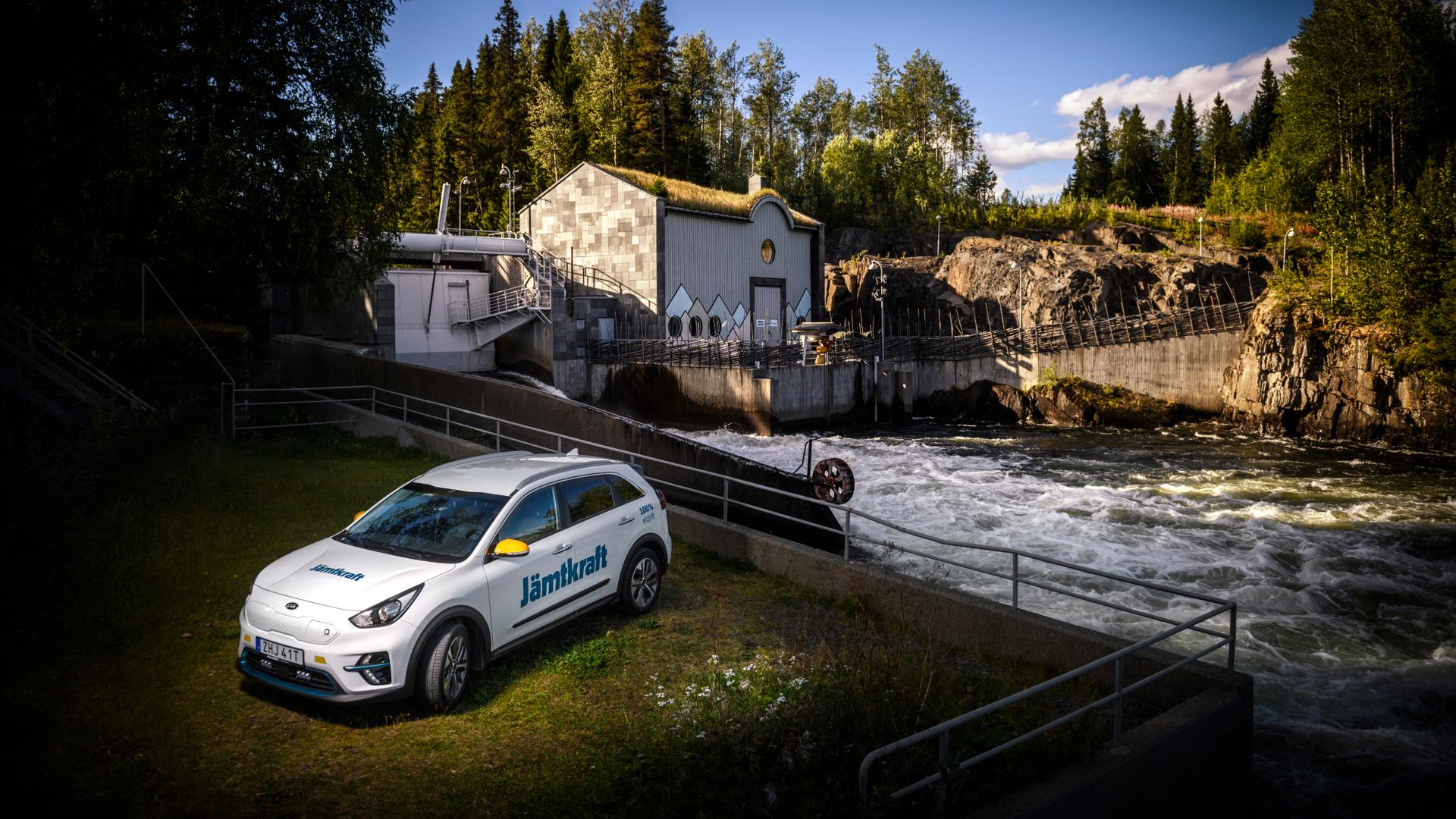 En vit bil med Jämtkrafts logotyp står vid vattenkraftverket i Rönnöfors.