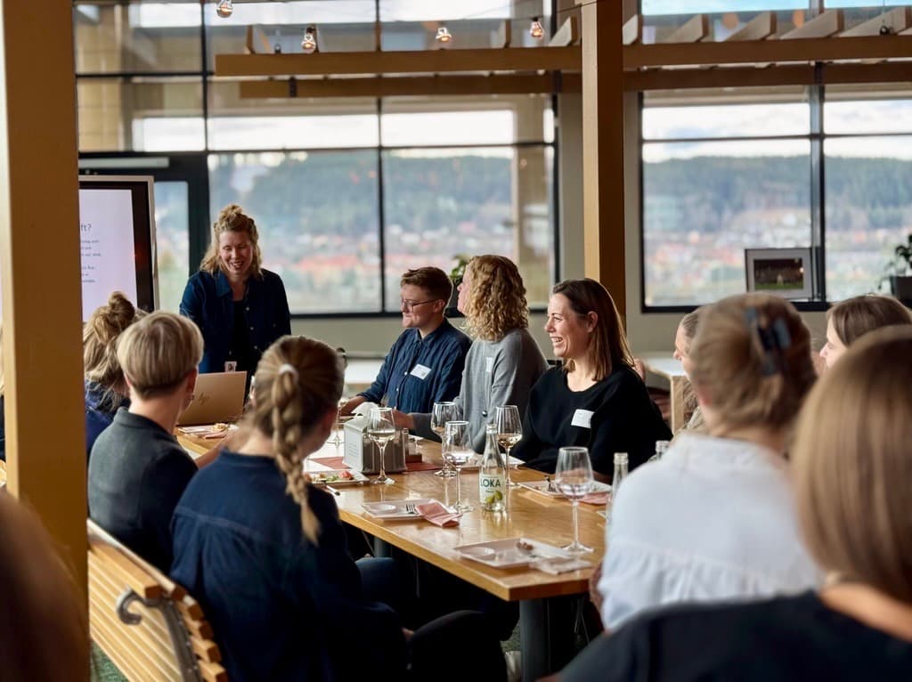 En grupp kvinnor som sitter vid ett långbord och konverserar.