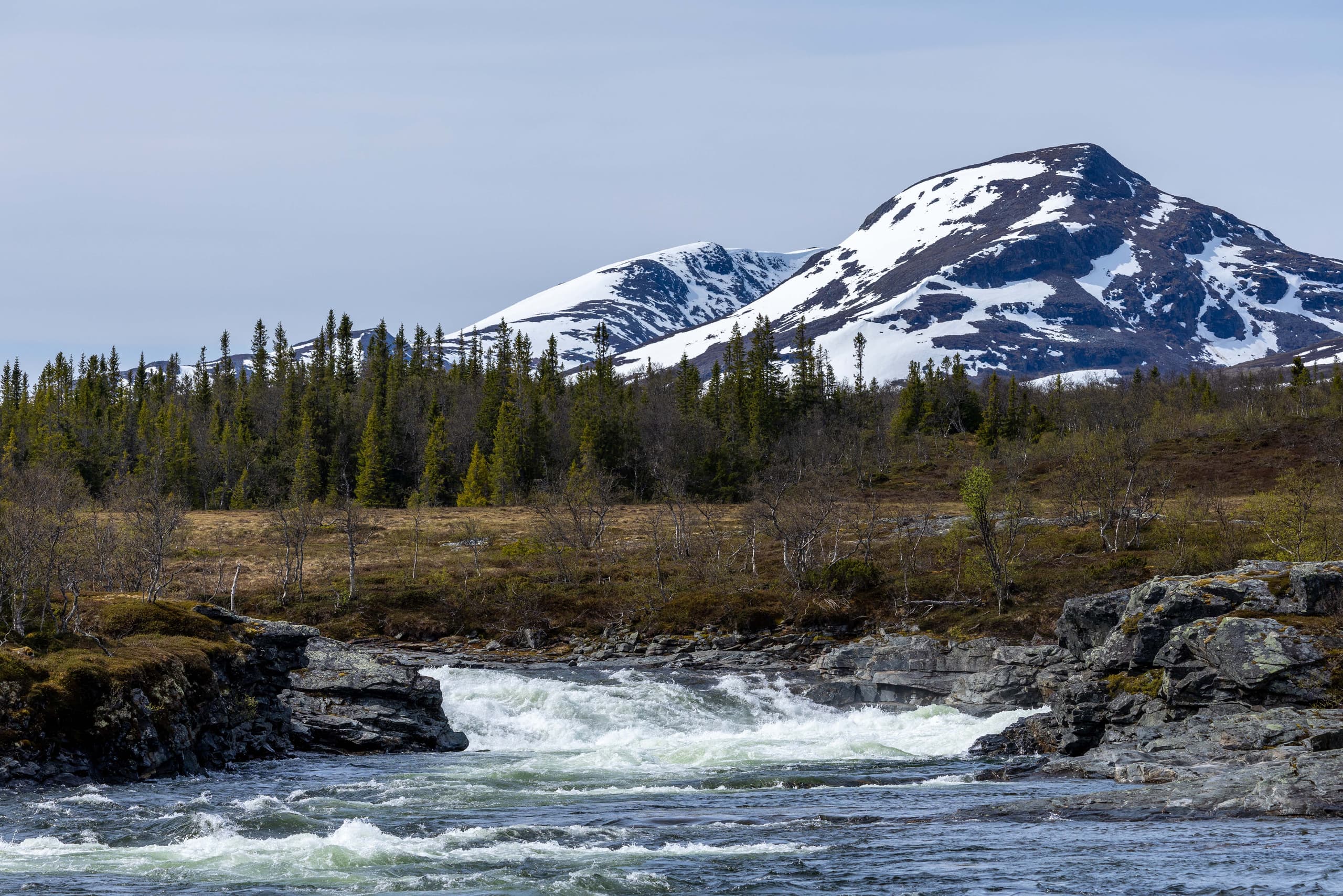 Handölsforsen med fjäll i bakgrunden.