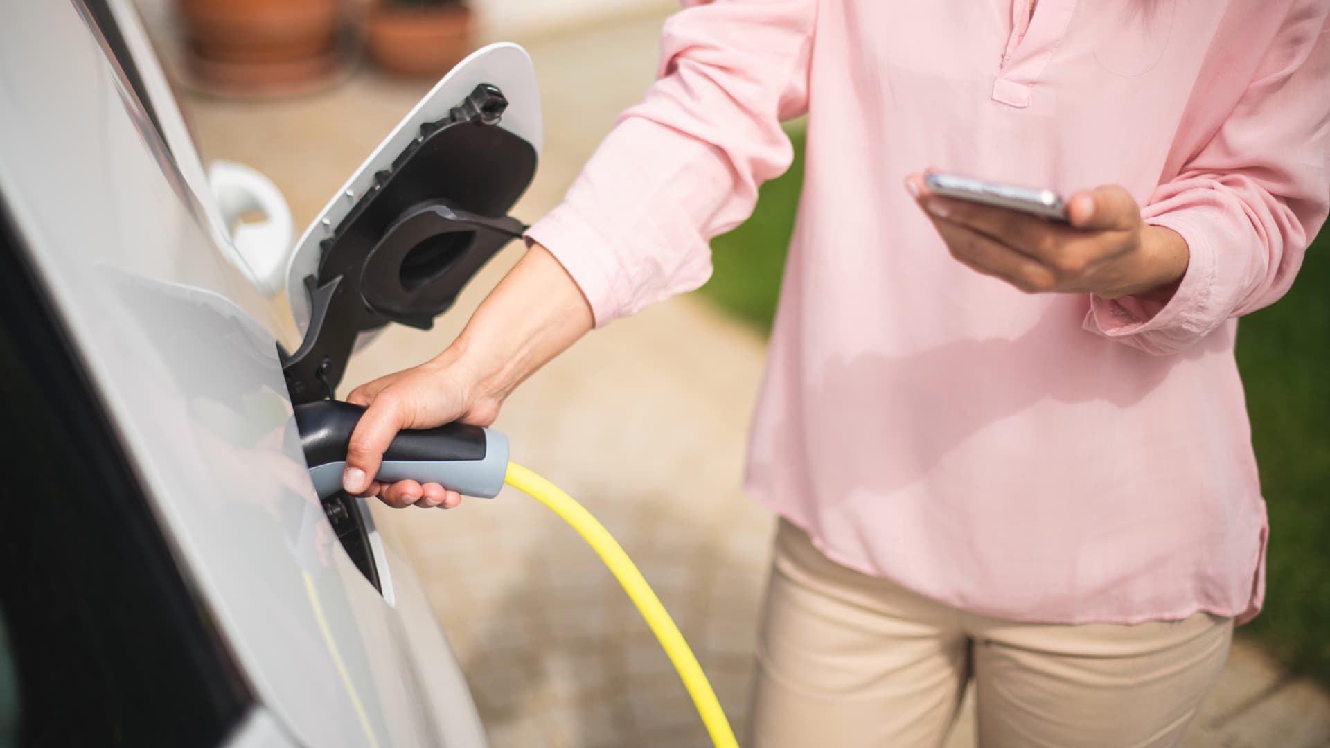 Kvinna laddar en elbil.