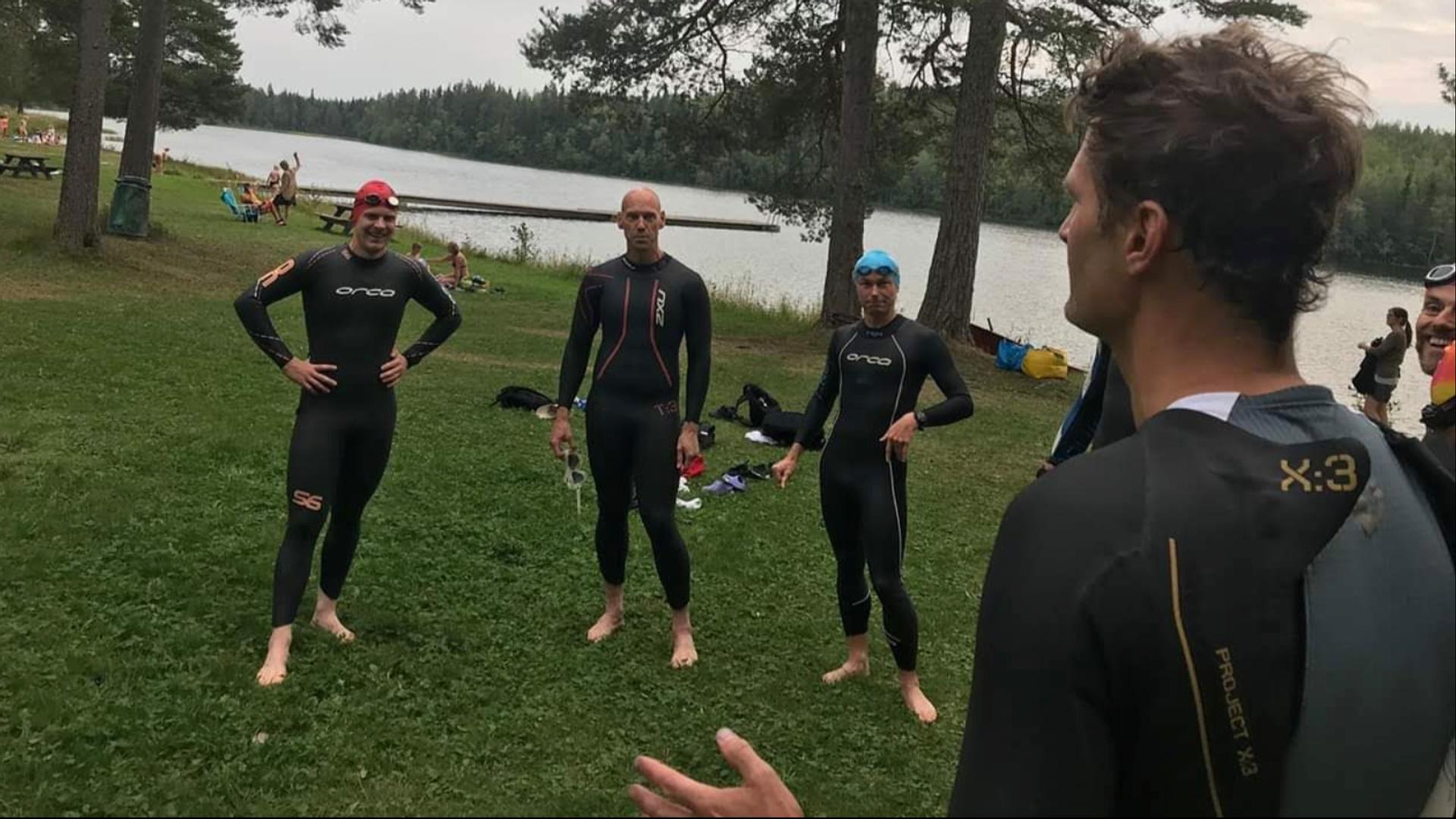 Några medlemmar i Östersund Triathlon står i våtdräkter och pratar.